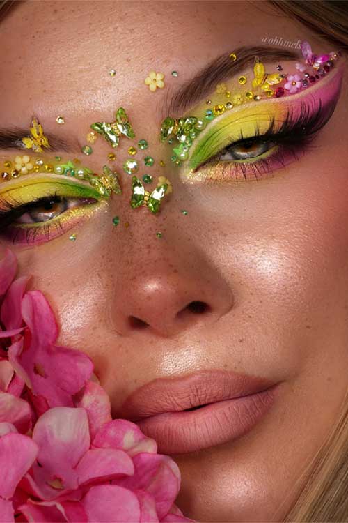 Colorful spring eyeshadow with blended pink, yellow, and green, accented by gold glitter, flowers, and butterflies for a whimsical touch. Colorful spring eyeshadow with blended pink, yellow, and green, accented by gold glitter, flowers, and butterflies for a whimsical touch.