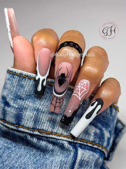 Long Black and white Halloween nails coffin shaped feature cobwebs, a spider, drip nail art, and white stars.