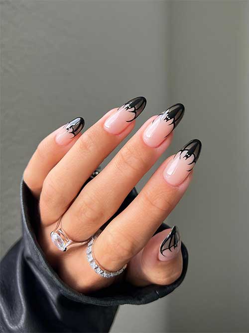 Long almond shaped Halloween bat French tip nails that feature a black bat on each nail tip.