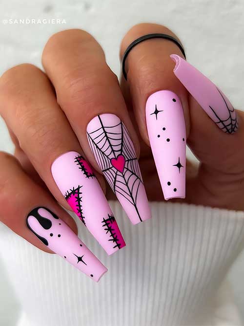 Long coffin matte pink gel Halloween nails feature cobwebs, stitches nail art, drip nail art, and black celestial nail art.