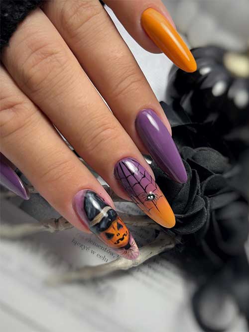 Long purple and yellow Halloween nails with spider, cobweb, and pumpkin nail art.