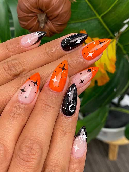 Orange and black Halloween nails with celestial nail art and two French accent nails.