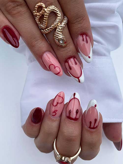 Red Halloween nails almond-shaped features blood drip nail art and two accent white French tip nails.