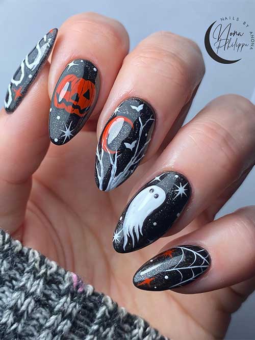 black and silver glitter Halloween nails, a ghost, a pumpkin, a cobweb, celestial nail art, and a boo word on the thumb nail