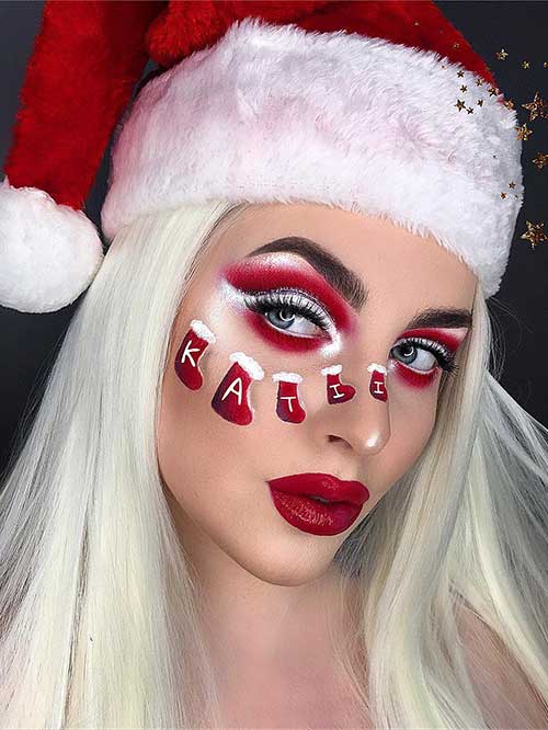 Red and white Xmas makeup with a touch of silver glitter, glossy red lips, and Santa Claus boots on the cheek