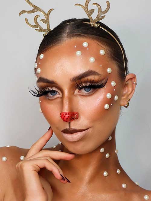 Rudolph the red-nosed reindeer makeup with extra long false lashes, nude lower lip, dark brown upper lip, and white pearls