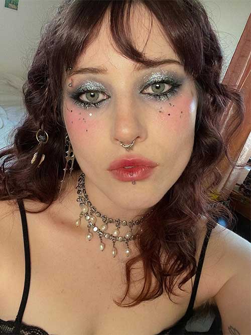 Silver glitter Christmas makeup look using silver glitter eyeshadow, mini silver stars glitter for the face, and red lips