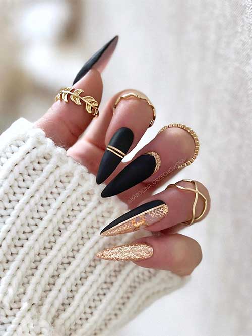 Stunning long almond shaped matte black nails with gold glitter design
