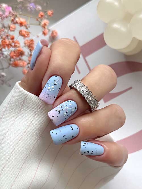 Matte light blue nails with ombre pink accents and white butterflies, featuring subtle black speckles for a whimsical touch. Matte light blue nails with ombre pink accents and white butterflies, featuring subtle black speckles for a whimsical touch.