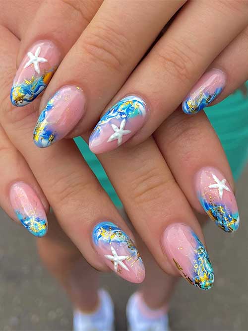 Angled ocean-themed nails with swirling blues, gold foil, and 3D starfish, perfect for beach weddings or tropical trips. Angled ocean-themed nails with swirling blues, gold foil, and 3D starfish, perfect for beach weddings or tropical trips.