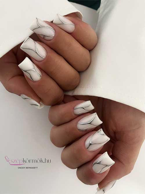 Chic white nails featuring striking silver lines for a three-dimensional look, ideal for those who love unique elegance. Chic white nails featuring striking silver lines for a three-dimensional look, ideal for those who love unique elegance.