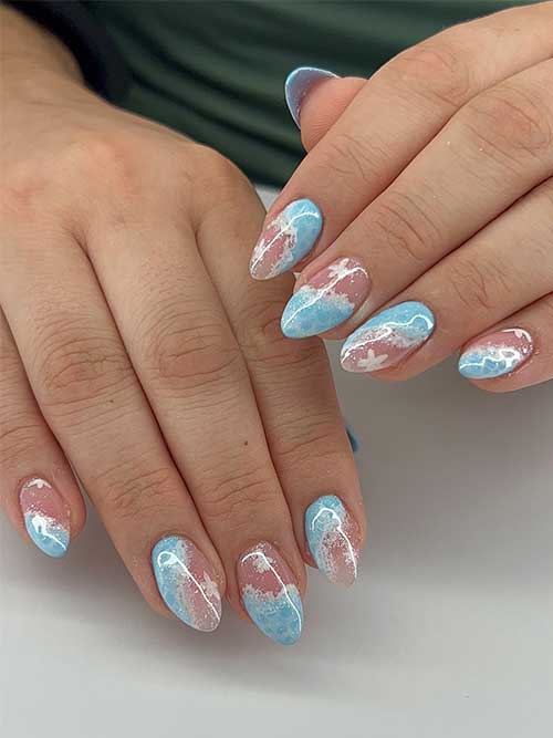 Dreamy almond-shaped ocean nails blend light blue and blush pink, accented with white clouds and starfish for a whimsical look. Dreamy almond-shaped ocean nails blend light blue and blush pink, accented with white clouds and starfish for a whimsical look.