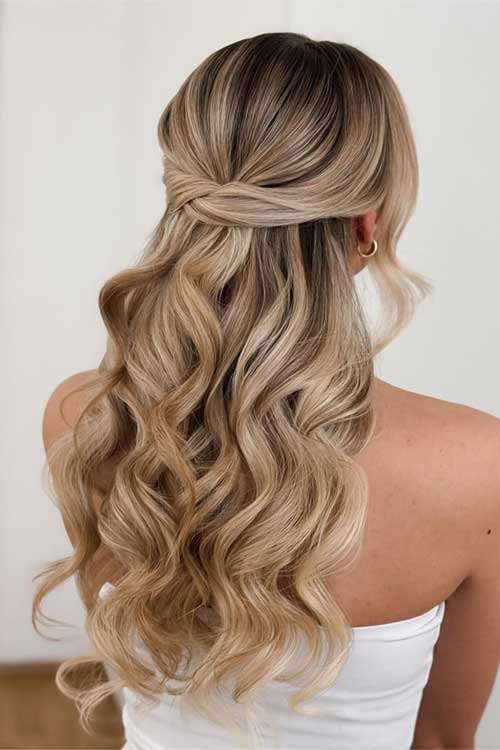 Elegant half-up, half-down hairstyle with voluminous curls and a twisted crown, featuring blended blonde balayage for a luxurious look. Elegant half-up, half-down hairstyle with voluminous curls and a twisted crown, featuring blended blonde balayage for a luxurious look.