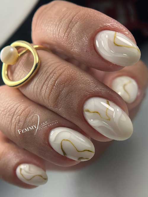 Elegant white nails with 3D gel swirls resembling marble, accented by shimmering gold liner for a unique, regal look. Elegant white nails with 3D gel swirls resembling marble, accented by shimmering gold liner for a unique, regal look.