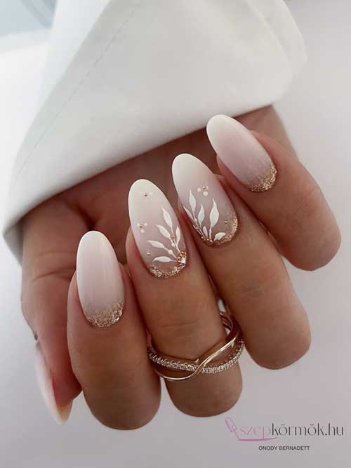 Exquisite bridal nails featuring a pink-to-white gradient, gold glitter, and floral accents, ideal for a sophisticated wedding style. Exquisite bridal nails featuring a pink-to-white gradient, gold glitter, and floral accents, ideal for a sophisticated wedding style.