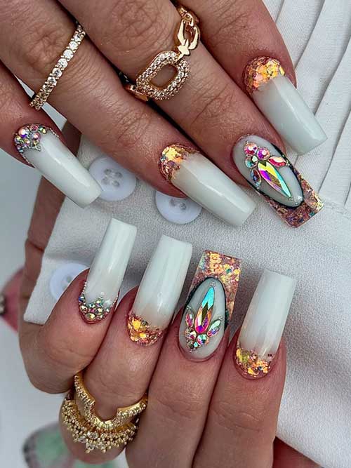 Long coffin-shaped white nails with a sparkling milky base, iridescent crystals, and rose gold glitter for a luxurious look. Long coffin-shaped white nails with a sparkling milky base, iridescent crystals, and rose gold glitter for a luxurious look.
