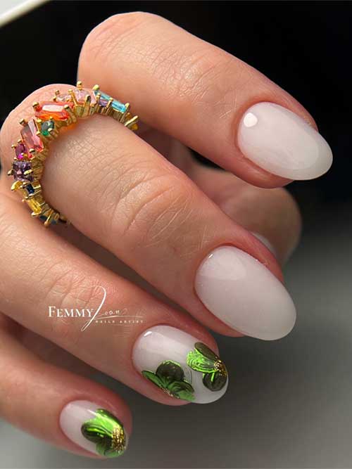 Soft white nails with a glass-like finish, featuring green-and-gold floral accents for a chic, nature-inspired look. Soft white nails with a glass-like finish, featuring green-and-gold floral accents for a chic, nature-inspired look.