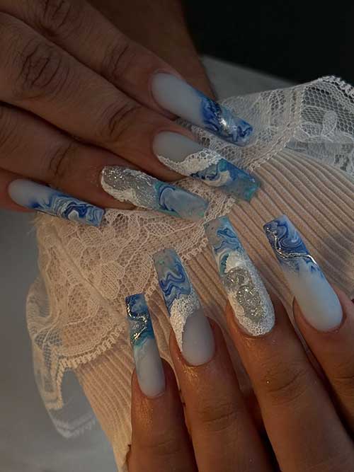 Square ocean nails with blue and white matte marbling, accented by glittery seafoam for a modern, elegant look. Square ocean nails with blue and white matte marbling, accented by glittery seafoam for a modern, elegant look.