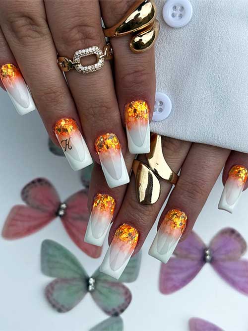 White ombre nails transitioning to orange glitter at the cuticle, combining elegance with a playful summer vibe. White ombre nails transitioning to orange glitter at the cuticle, combining elegance with a playful summer vibe.
